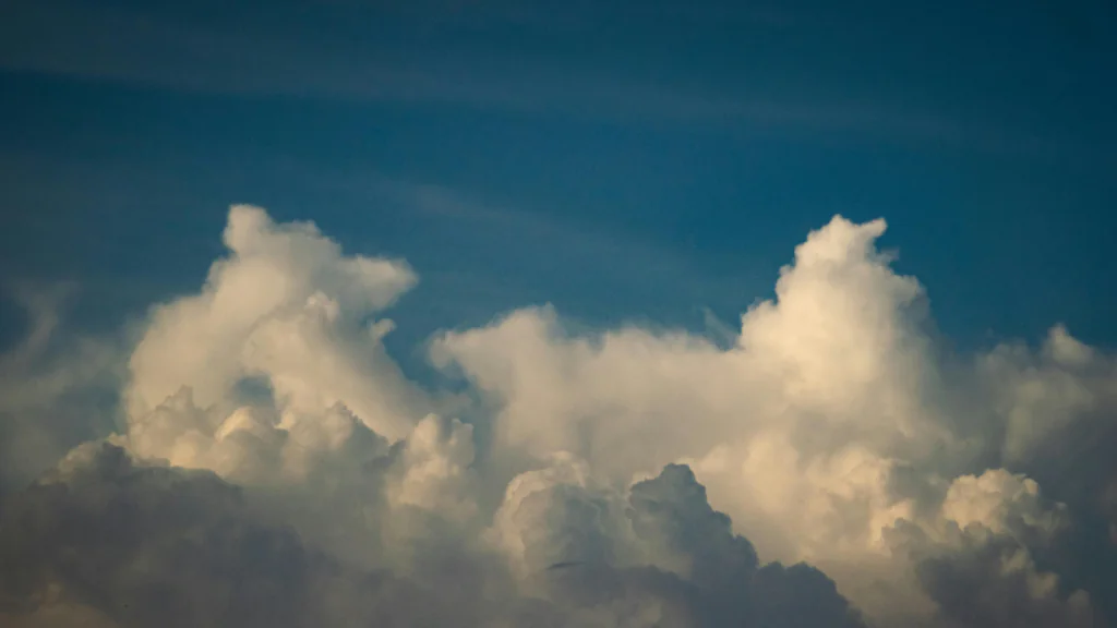 Storm clouds rising in a blue sky