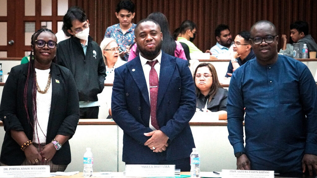 Three people stood behind desks
